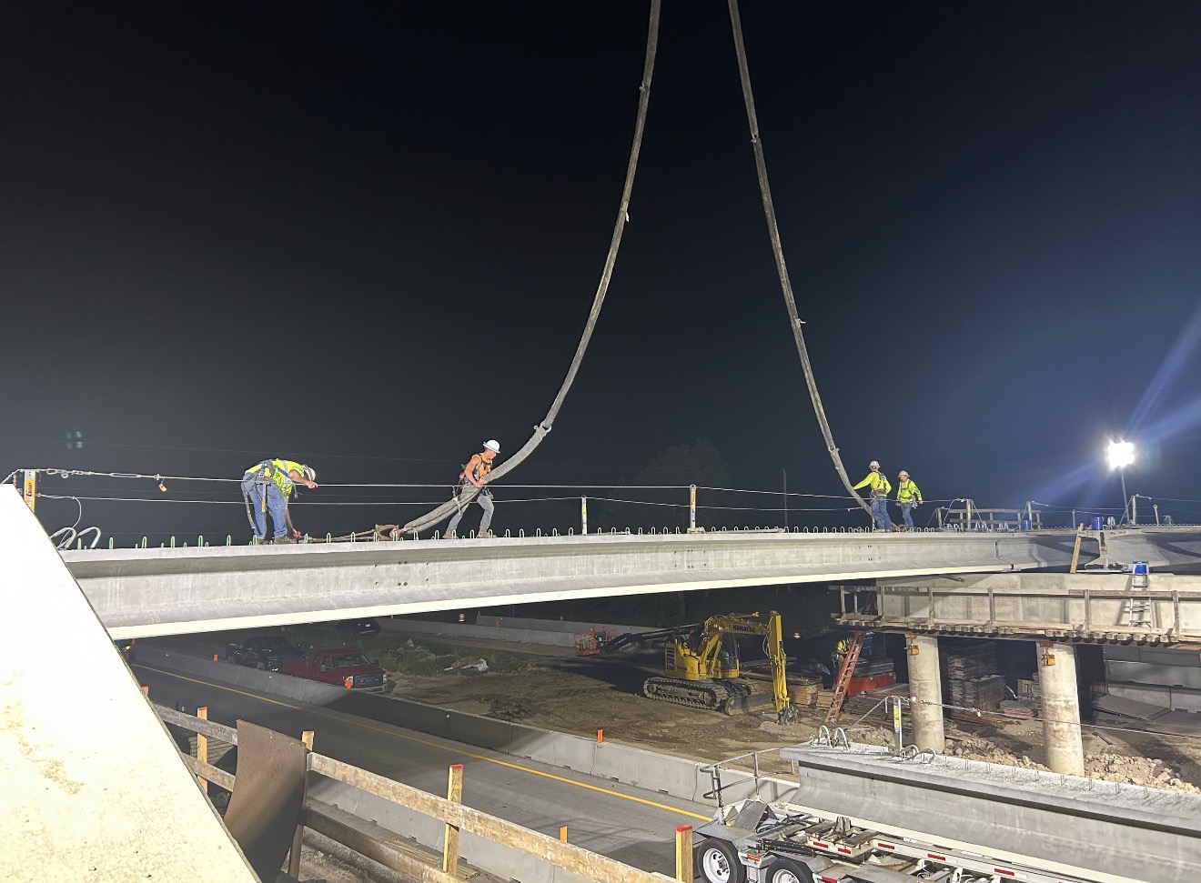 Crew placing concrete on bridge deck at night